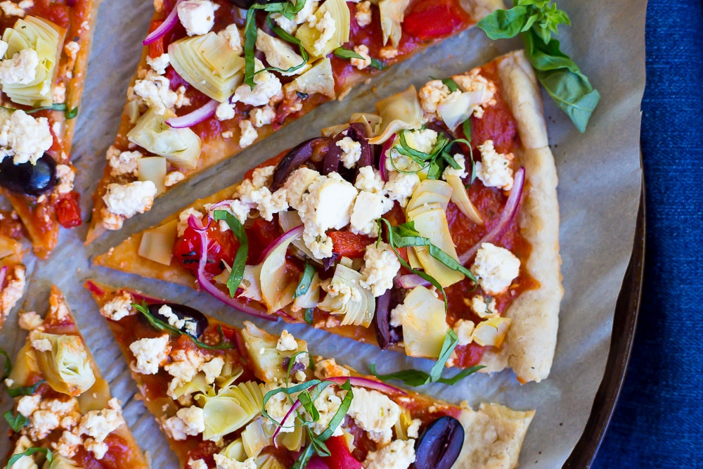 This Vegan Greek Pizza is so full of delicious and fresh flavor that you won't even miss the dairy! Vegan tofu feta adds tons of creaminess and tang! Perfect for your next pizza night!