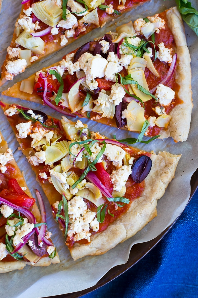 This Vegan Greek Pizza is so full of delicious and fresh flavor that you won't even miss the dairy! Vegan tofu feta adds tons of creaminess and tang! Perfect for your next pizza night!