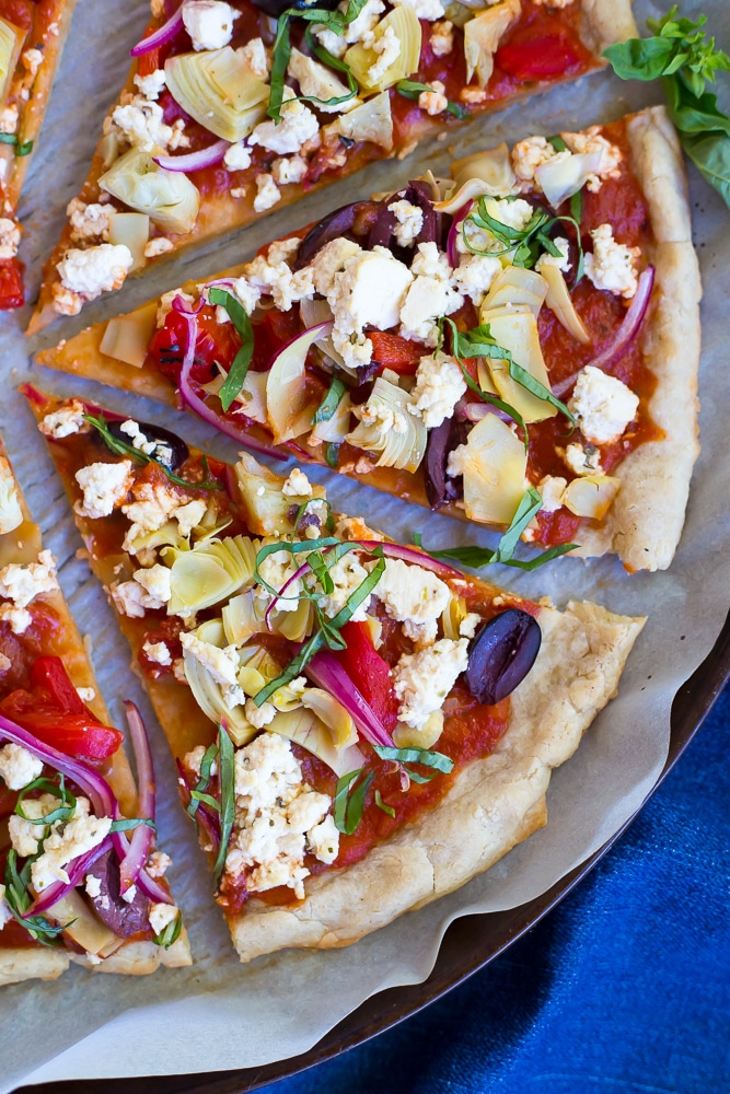 This Vegan Greek Pizza is so full of delicious and fresh flavor that you won't even miss the dairy! Vegan tofu feta adds tons of creaminess and tang! Perfect for your next pizza night!