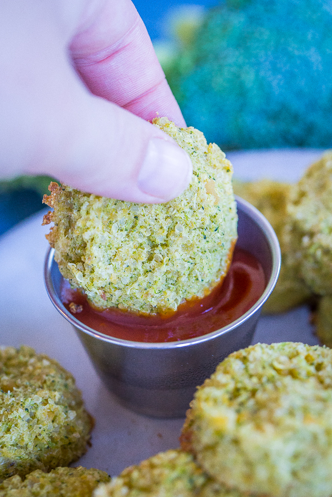 A hand dipping a Protein Packed Broccoli Cheese Bite into ketchup