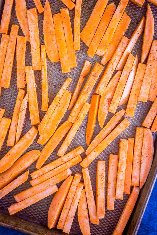 Sweet potatoes on a baking try before going into the oven for baked sweet potato fries recipe