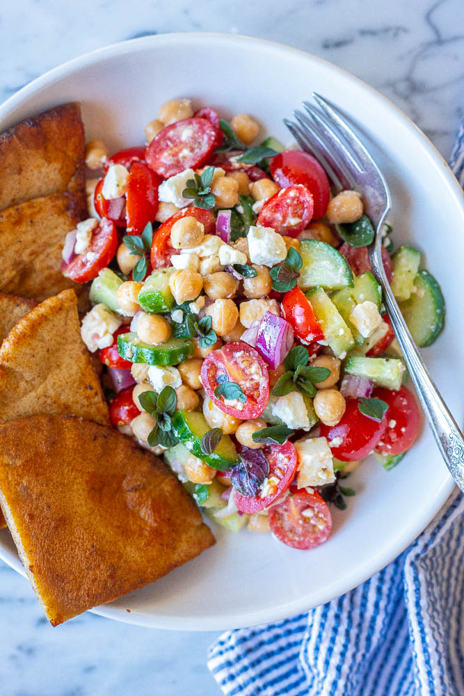 Close up of this easy chickpea salad recipe in a bowl with pita bread