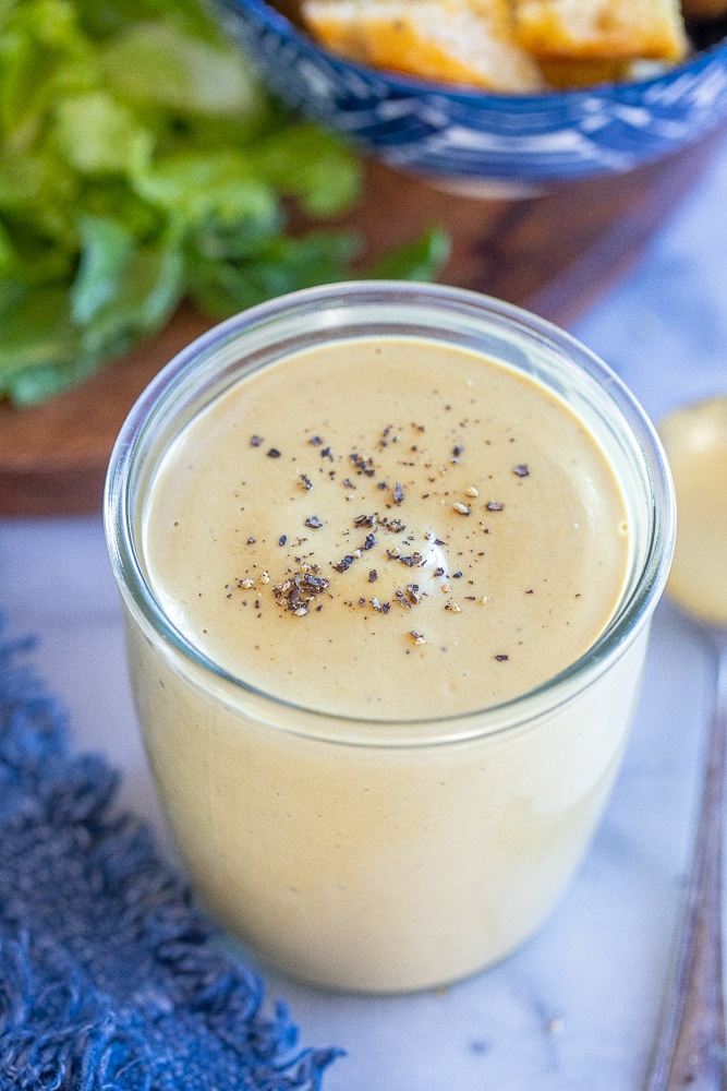 A jar filled with vegan caesar dressing