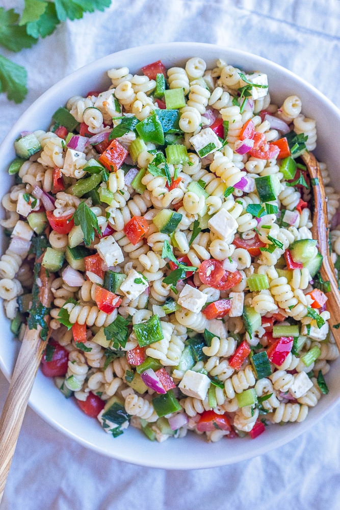 large bowl of easy vegetarian pasta salad with wooden spoons