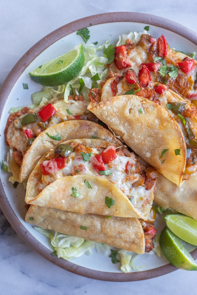 plate filled with crispy baked fajita tacos with fresh limes