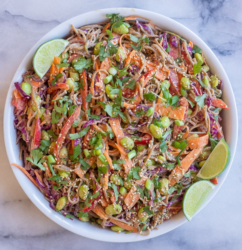 large serving bowl of cold peanut soba noodle salad with veggies