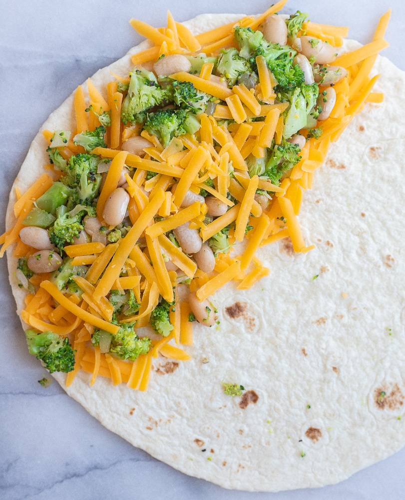 broccoli cheddar quesadillas being assembled before being cooked