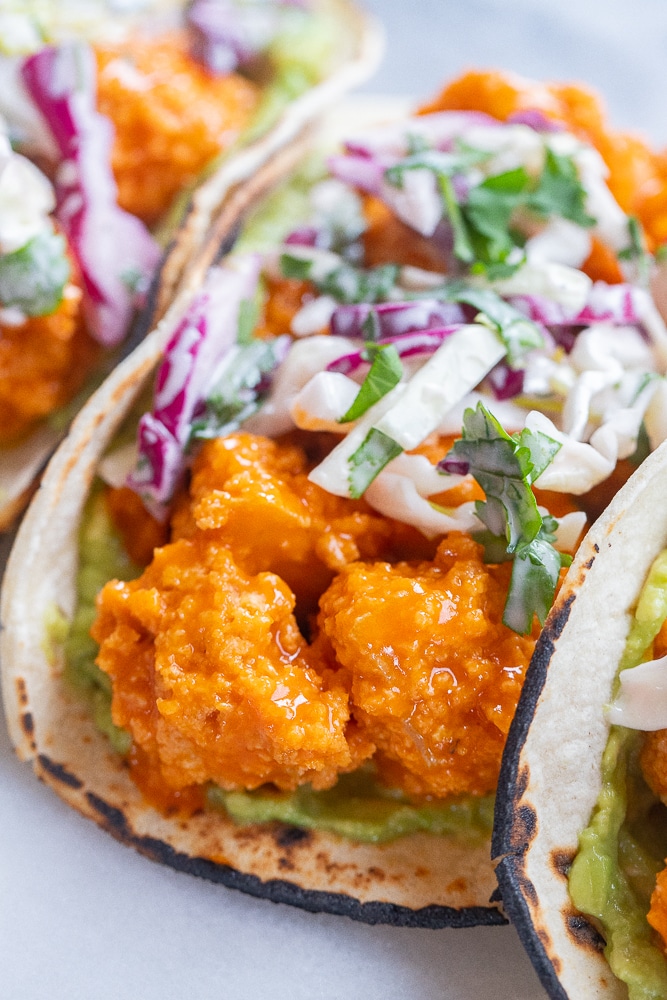 close up of crispy buffalo tofu bites in a taco