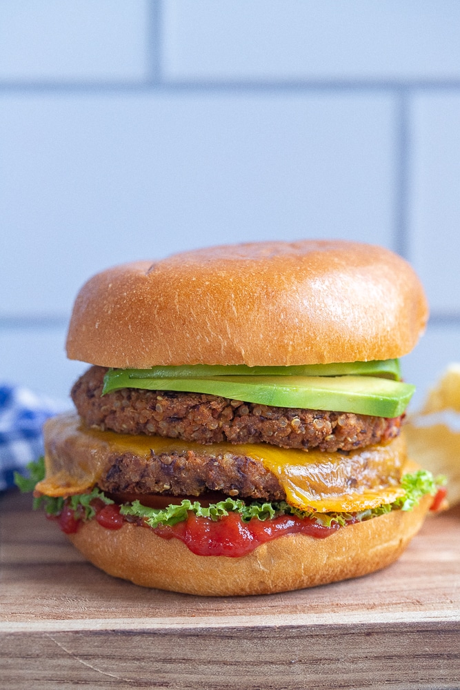 black bean veggie burger with melted cheese on a cutting board