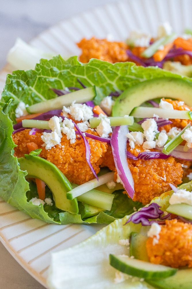 close up of a buffalo tofu lettuce wrap on a plate
