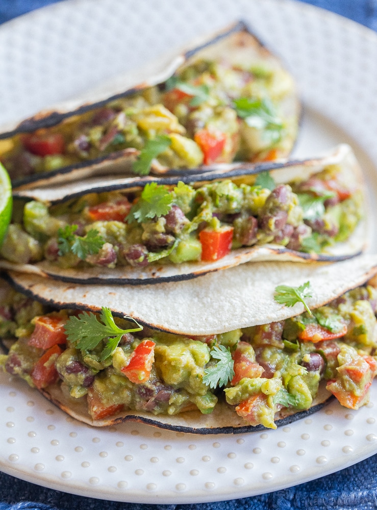 close up of black bean avocado tacos on a plate