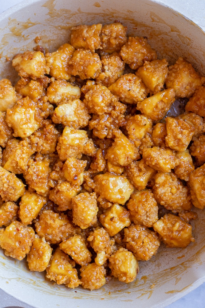 crispy orange tofu in a pan with sauce