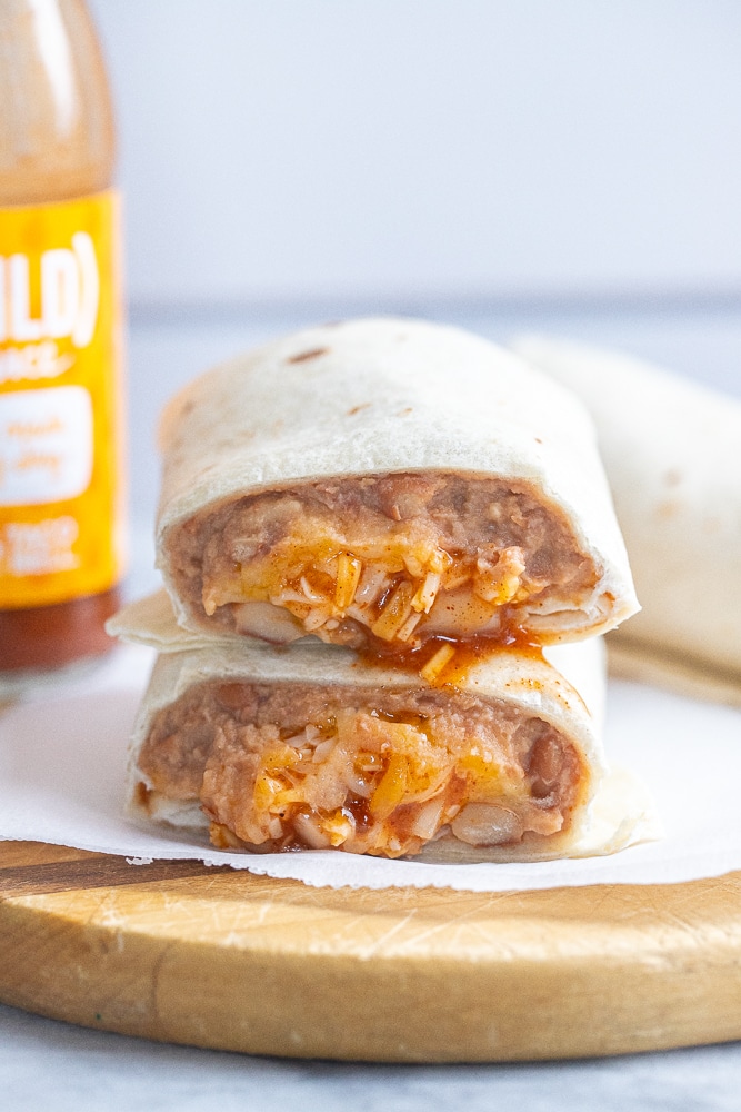 Taco Bell copycat bean and cheese burrito recipe on a cutting board sliced in half