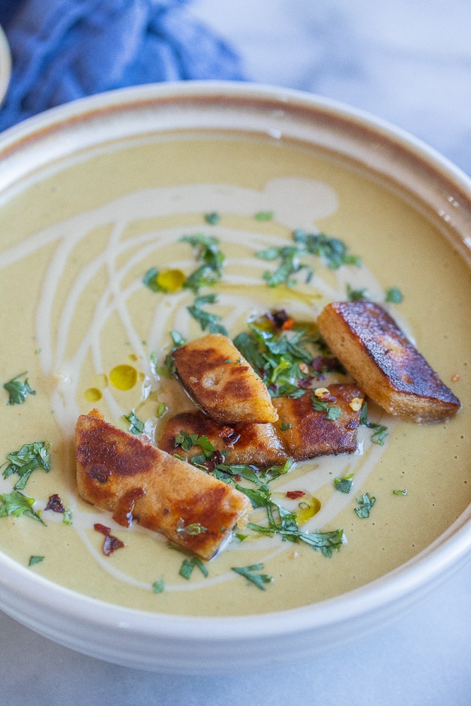 close up of falafel flavored chickpea soup in a bowl with crispy pita bread on top
