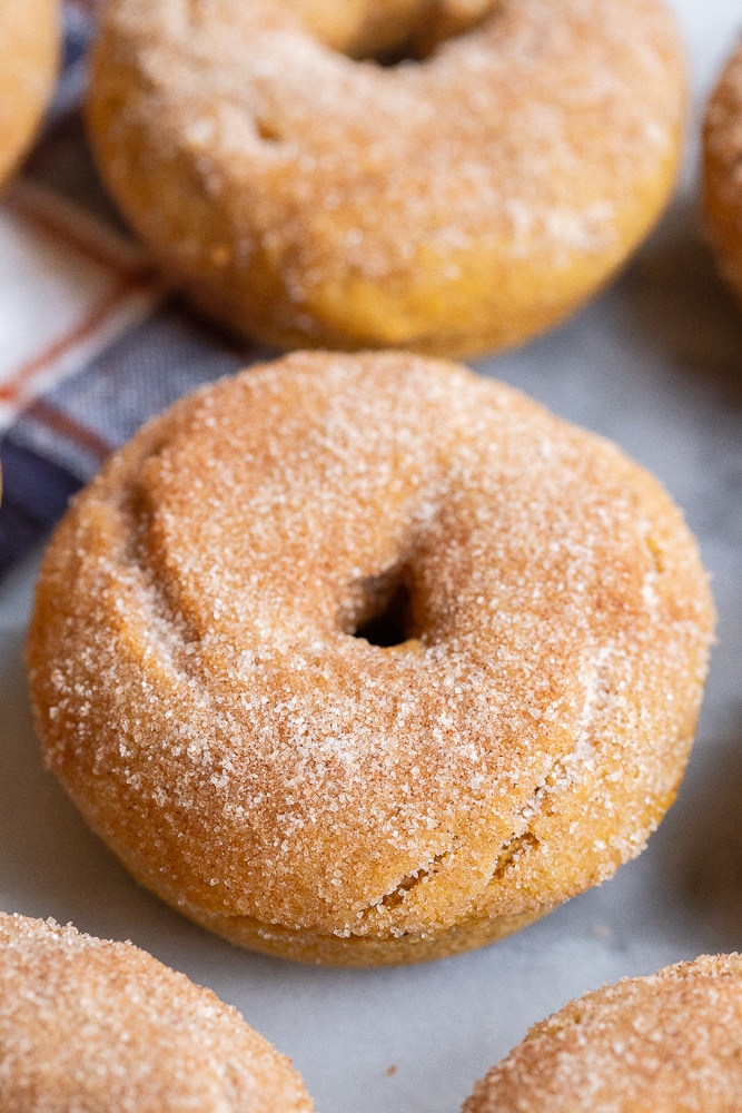 close up of a baked gluten free pumpkin muffin topped with cinnamon and sugar