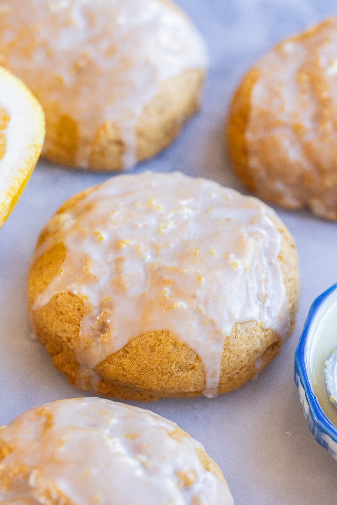 close up of an orange glazed soft pumpkin cookie