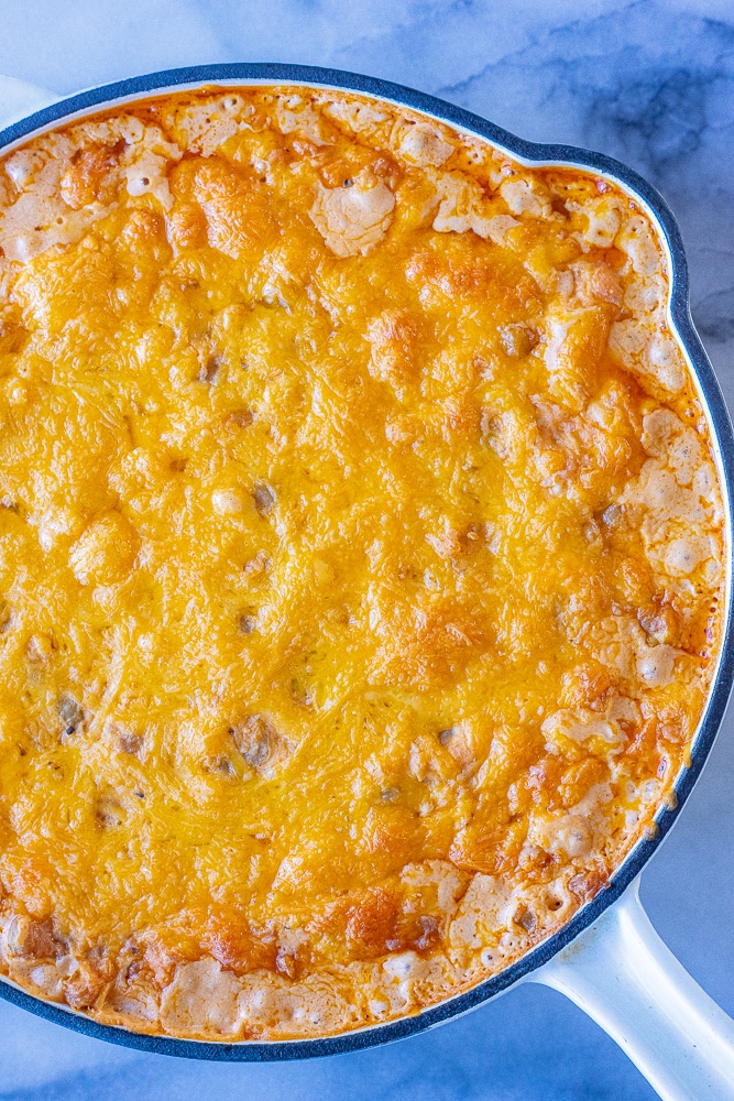 close up of a bubbling pan of cheesy vegetarian buffalo chickpea dip