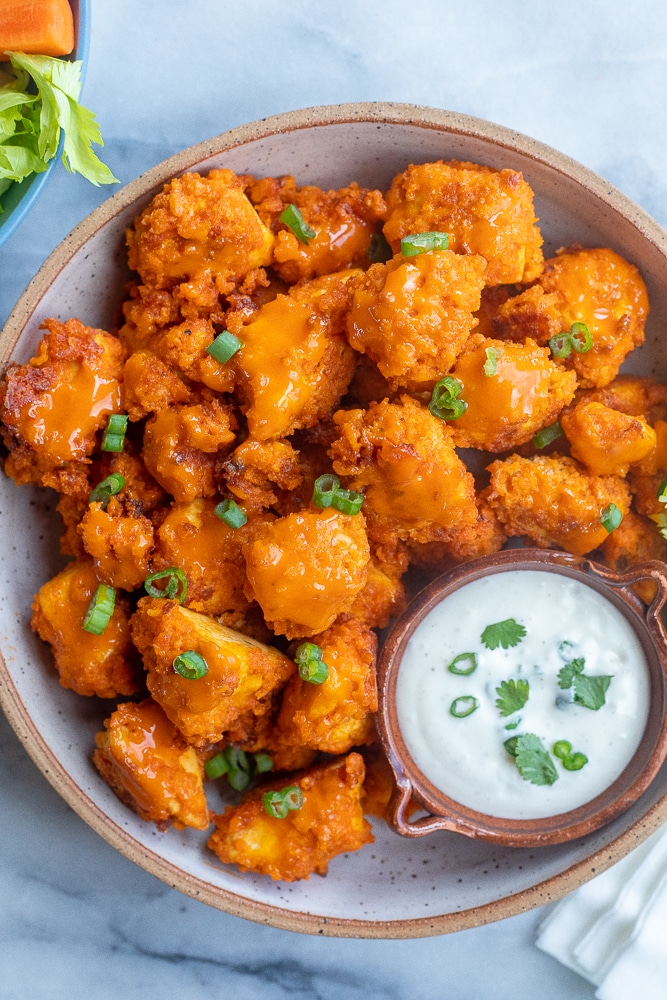 bowl of crispy tofu wings with a side of ranch dressing