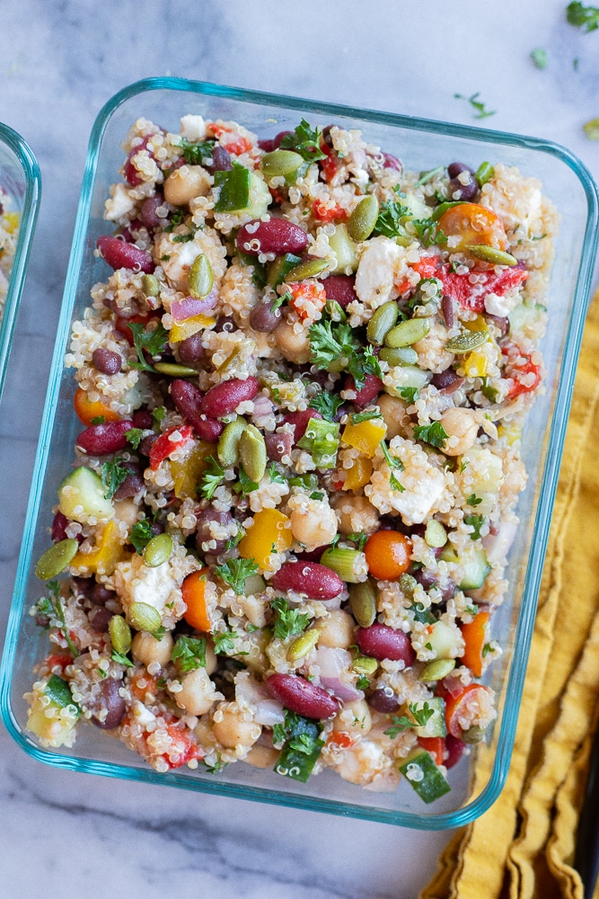 close up of a glass meal prep container filled with three bean quinoa salad meal prep bowls