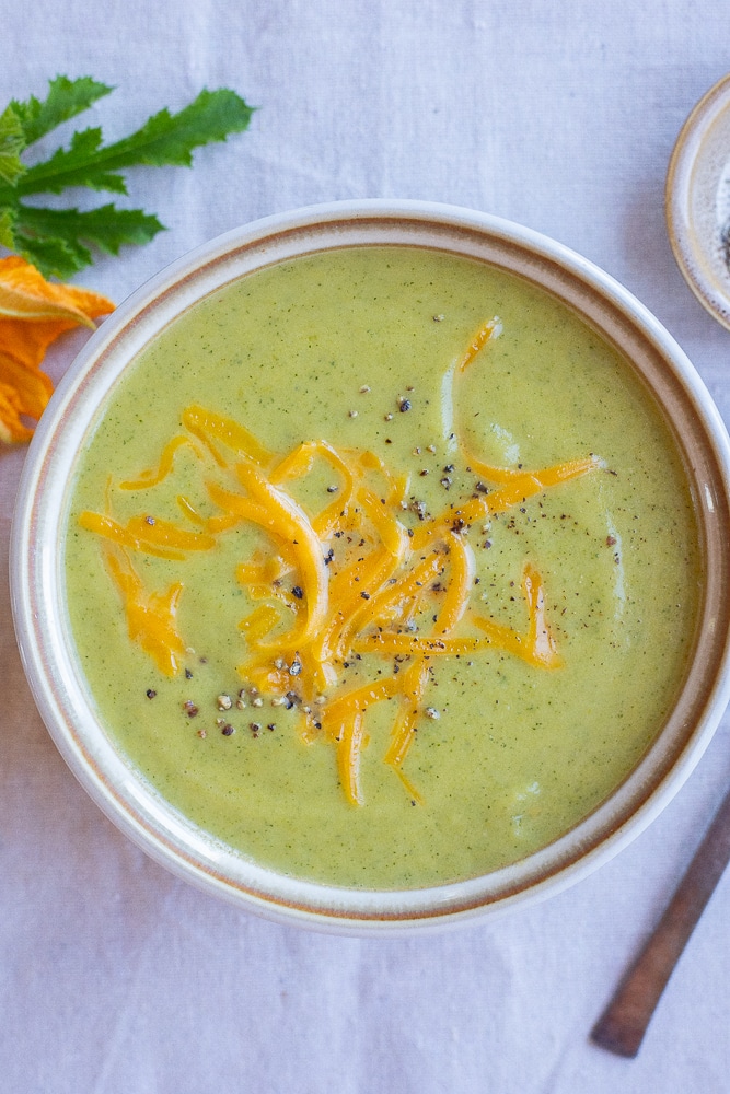 cheesy zucchini soup in a bowl with black pepper
