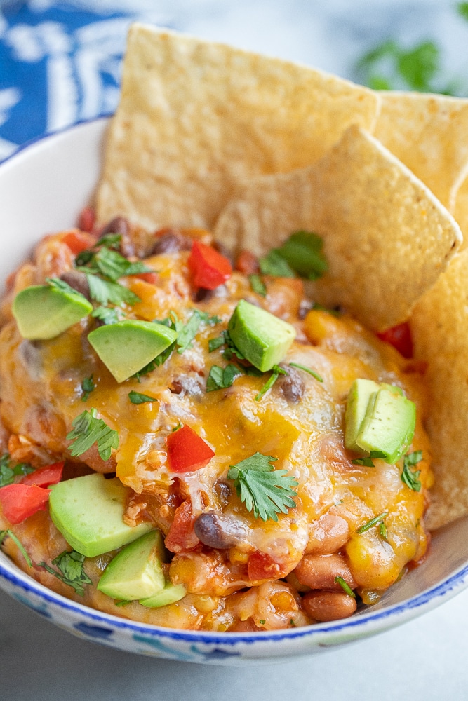 close up of cheesy vegetarian taco skillet with tortilla chip