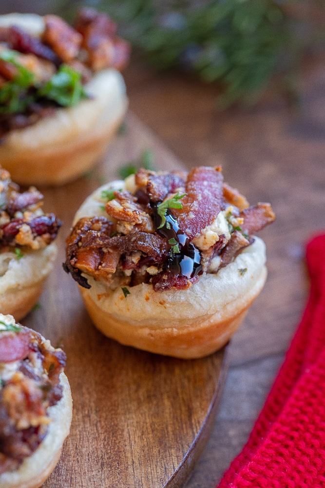 close up of a balsamic onion and goat cheese puff pastry bite on a cutting board