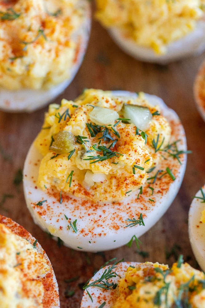 close up of a dill deviled egg garnished with paprika