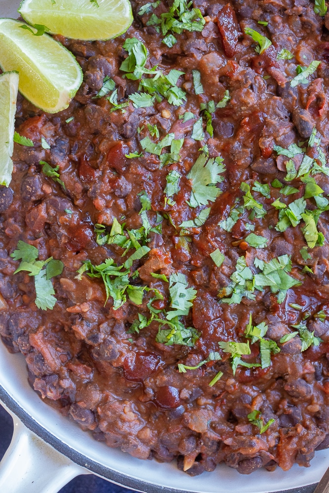 close up of a pan of chipotle black beans topped with cilantro