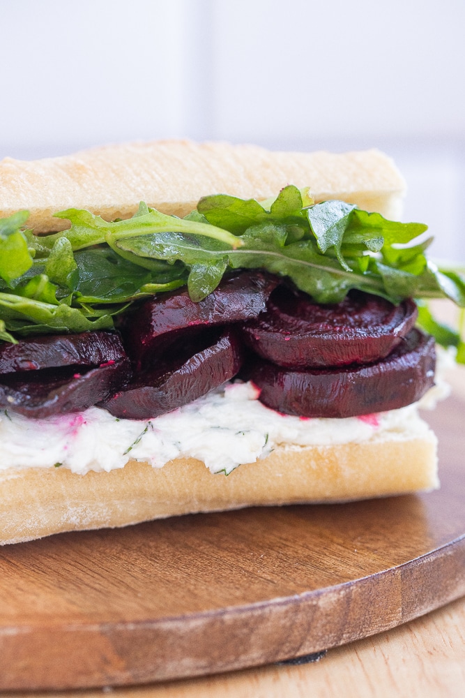 close up of a baguette with dill and horseradish goat cheese, roasted beets and arugula