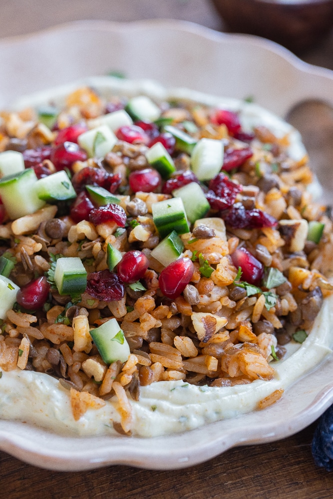 close up of lentils and rice on a plate with curry yogurt sauce on the bottom