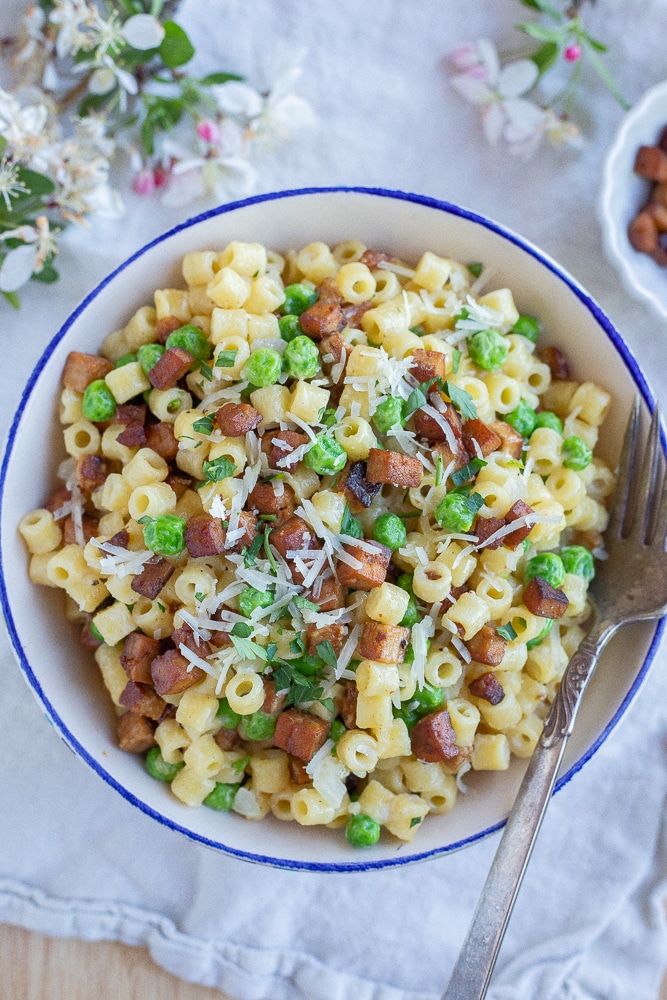 bowl of parmesan pasta with peas and pancetta