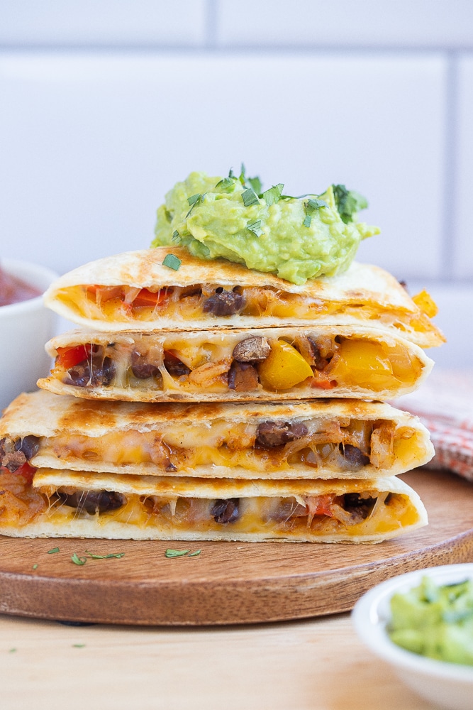 a stack of rice and bean fajita quesadillas on a cutting board