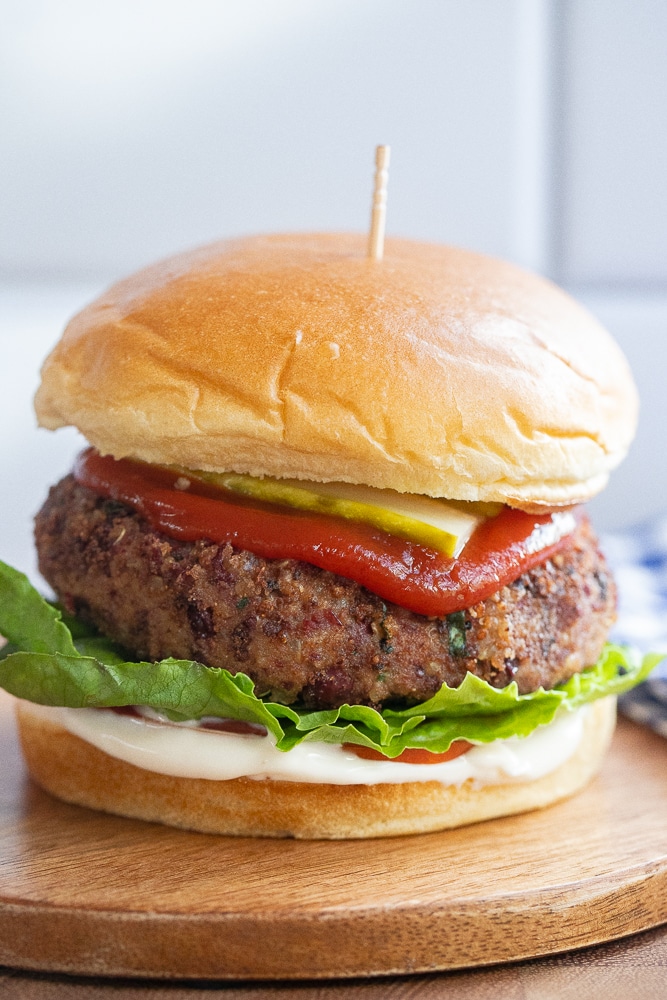 close up of a high protein kidney bean burger with tomato, lettuce and pickles