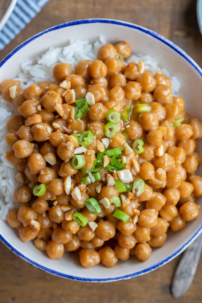 close up of a bowl of peanut butter chickpeas topped with green onions