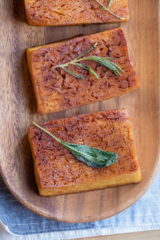 garlic herb butter tofu steaks on a wooden platter