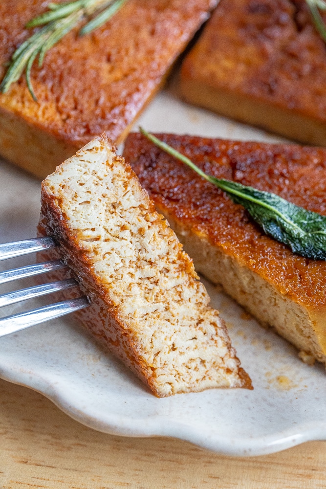 garlic butter tofu that has been cut with a knife and fork