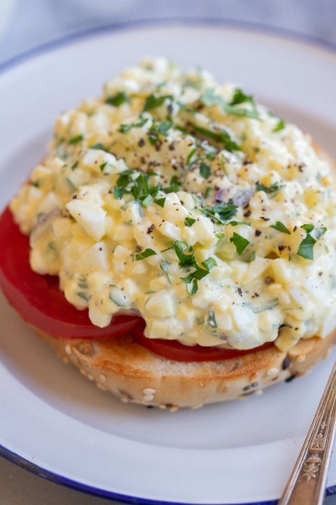 close up of a bagel topped with tomato and high protein egg cottage cheese salad