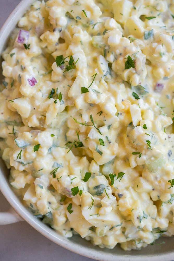Bowl of high protein cottage cheese egg salad with fresh herbs on top