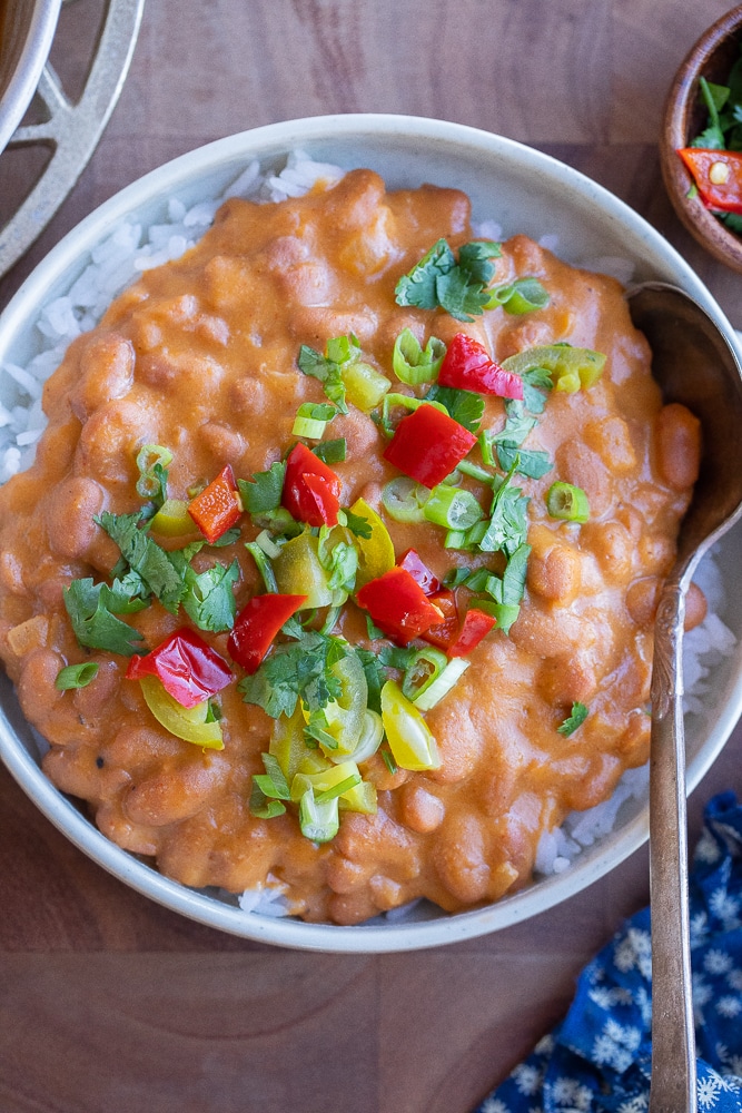 cheesy beans with rice and toppings in a bowl