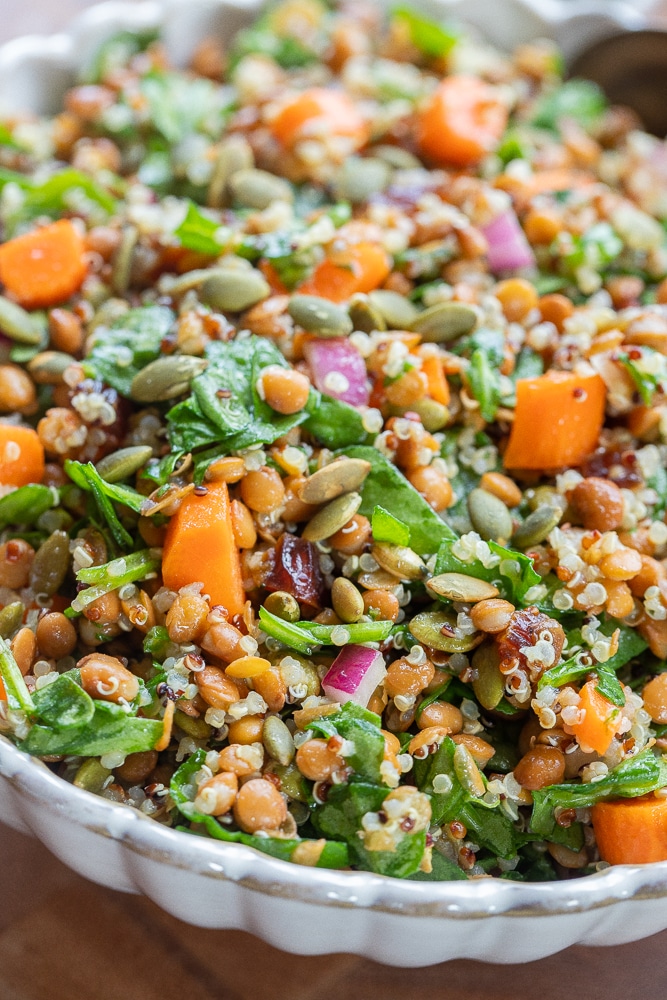 Large bowl of iron rich spinach lentil salad with quinoa and carrots