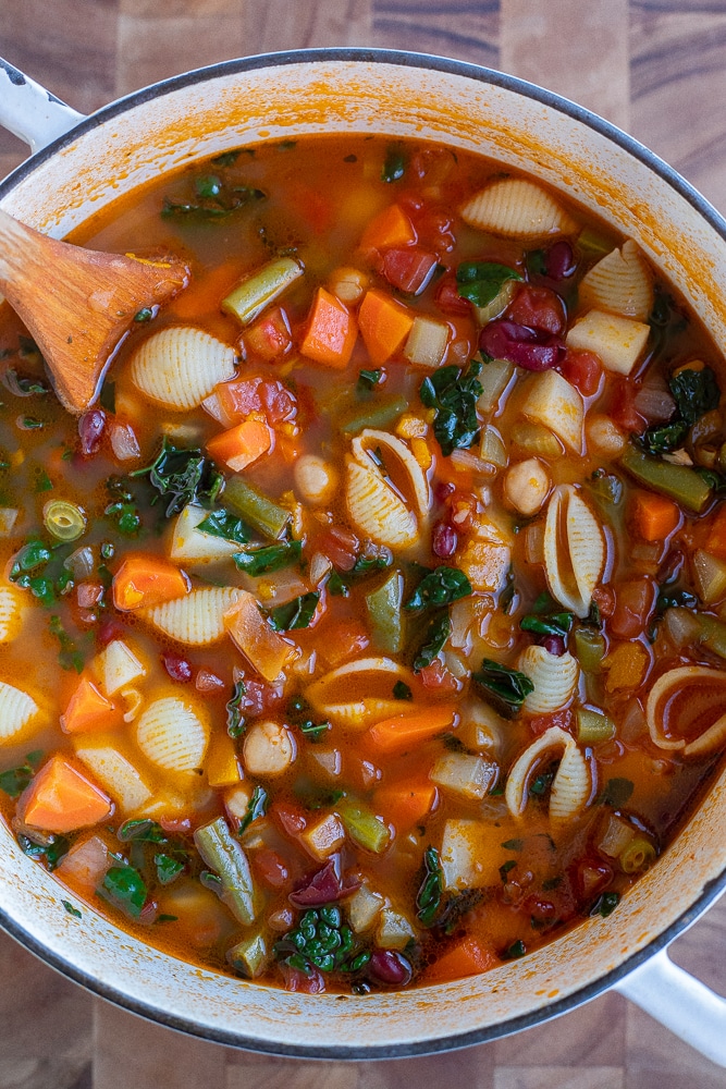 pot of minestrone soup with a wooden spoon in it