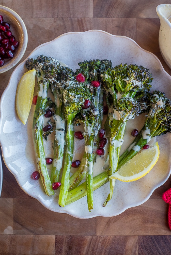 serving platter full of roasted broccolini topped with tahini dressing