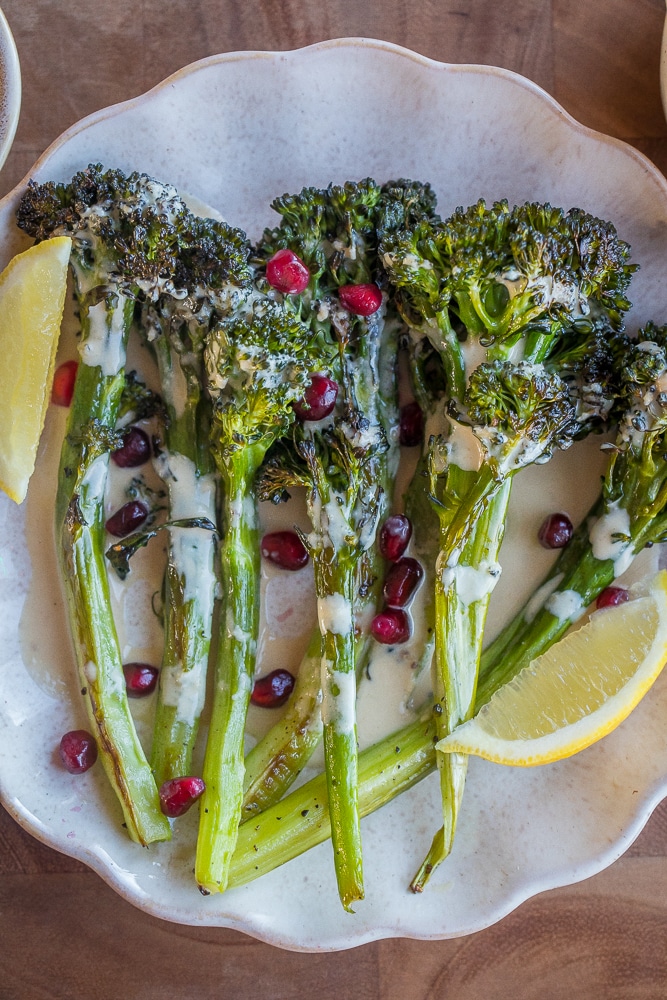 close up of a plate full of roasted broccolini with lemon tahini dressing