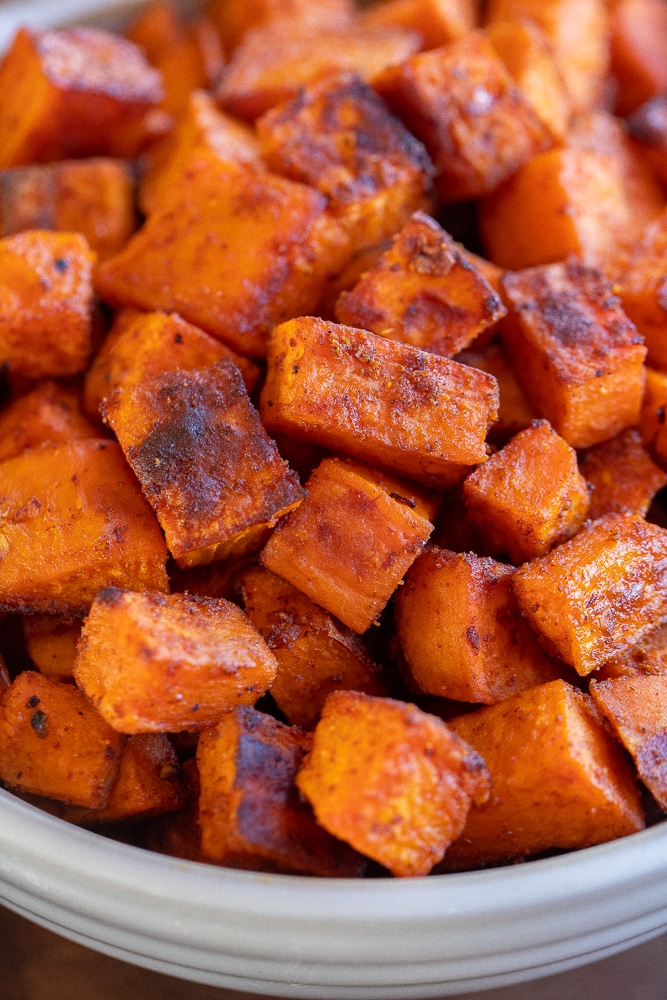 close up of seasoned roasted sweet potatoes in a bowl