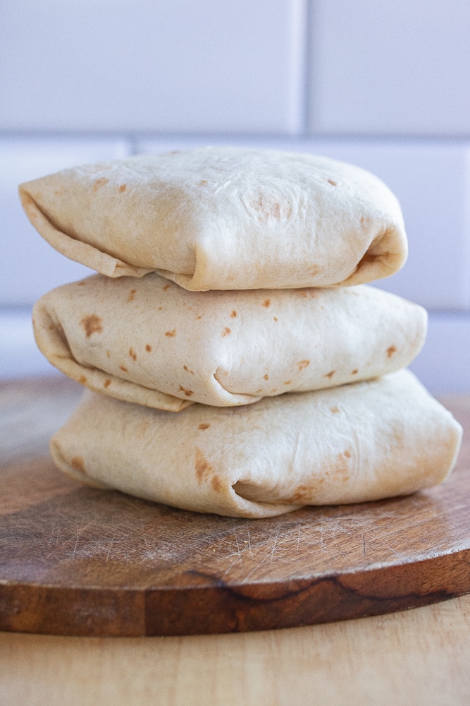 three breakfast wraps folded up and stacked on top of eachother