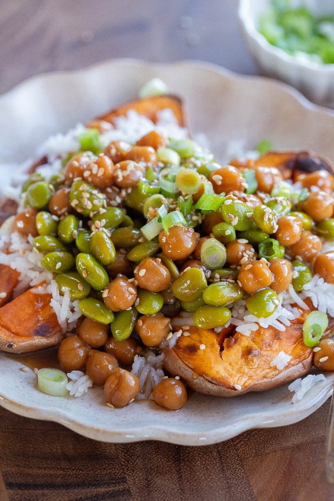 close up of a sweet potato stuffed with teriyaki edamame and chickpeas