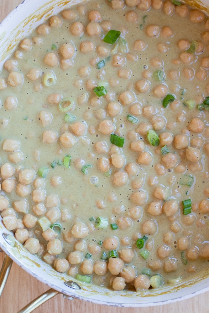 Pan full of chickpeas in green curry sauce