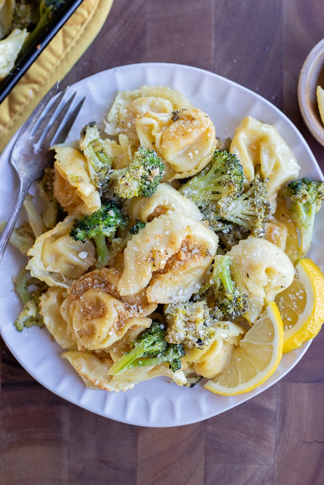 dinner plate full of roasted tortellini with broccoli and parmesan